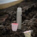 a couple of cups sitting on top of a rocky hillside